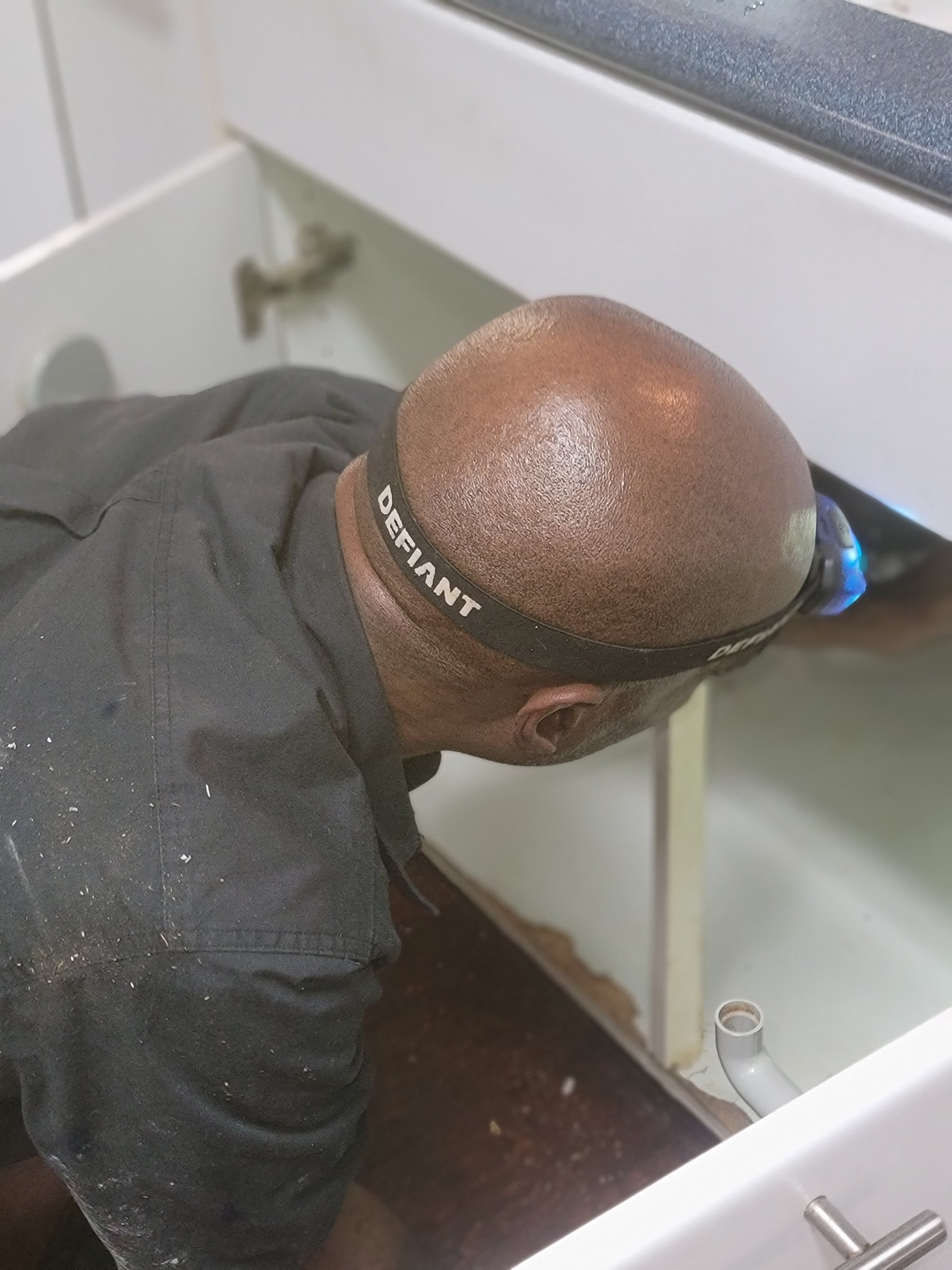 Michael working under a sink